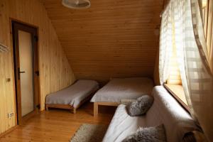 a room with two beds in a wooden cabin at Sodyba "Baltalaukis" in Didžiosios Kabiškės +35 photos