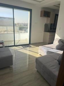 a bedroom with two beds and a large window at La chebba plage in Chebba