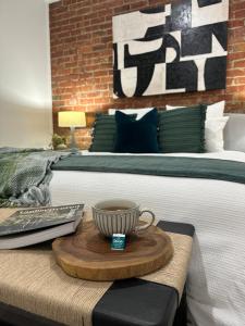 a bed with a table with a coffee cup on it at Modern Soho Pad with Sunny Deck in West Hobart