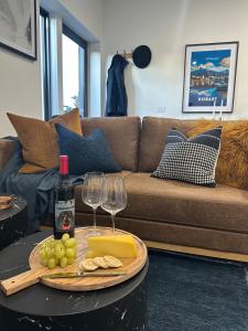 a living room with a table with wine glasses and cheese at Modern Soho Pad with Sunny Deck in West Hobart