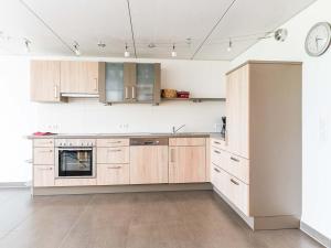 a kitchen with wooden cabinets and a clock on the wall at Ferienhof Rummel Allgäu - verschiedene Unterkünfte für bis zu 6 Personen - Sauna, Spielplatz, Lagerfeuer & Frühstücksservice - ideal für Familien- und Aktivurlaub in Argenbühl