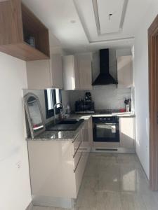 a kitchen with white cabinets and a sink at La chebba plage in Chebba