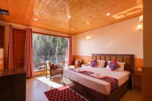 a bedroom with a bed and a large window at The Himvan Stay in Mundaghat 