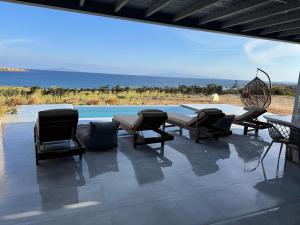 a patio with chairs and a table and a pool at Drios Hillhouse II in Drios
