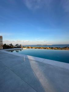 a swimming pool with the ocean in the background at Drios Hillhouse II in Drios