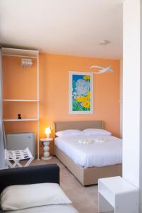 a bedroom with two beds and an orange wall at Attico Belvedere Randi in Ravenna +39 photos