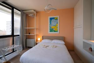 a bedroom with a large white bed and a window at Attico Belvedere Randi in Ravenna