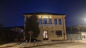 a building with a car parked in front of it at Pensiunea Casa Mitus in Strehaia