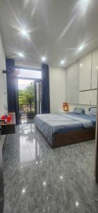 a bedroom with a bed and a large window at COMIC Homestay in Danang