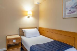 a small room with a bed and a night stand at Carrington House Hotel in Bournemouth