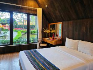 a bedroom with a bed and a desk and a window at TTC Dreamy Hill Resort - Unlimited Access to TTC World - Thung Lung Tinh Yeu in Da Lat