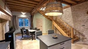 a dining room with a table and chairs and a staircase at La Ferme du Château in Beire-le-Châtel
