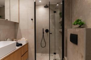 a shower with a glass door in a bathroom at Opus Boutique Apartment in Alexandroupoli +49 photos