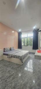 a bedroom with a large bed with blue curtains at COMIC Homestay in Danang