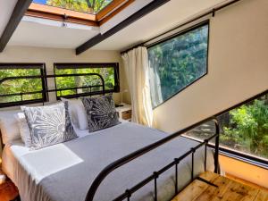 a bedroom with a bed and large windows at ZenCapeTown Forest Retreat in Cape Town