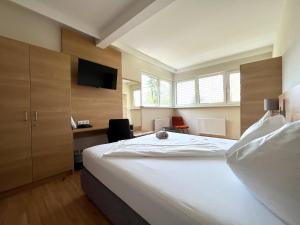 a bedroom with a bed and a desk and a television at Hotel Grazerhof in Bad Gleichenberg