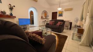 a living room with two couches and a television at Luxury 3Bedroom Villa with Pool, Garden & Sunset in Tala
