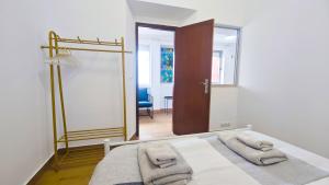 a bedroom with a bed with two towels on it at Cascais Garden House 101 in Cascais