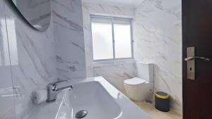 a white bathroom with a sink and a toilet at Cascais Garden House 101 in Cascais +3 photos