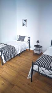 two beds in a room with a wooden floor at Cascais Garden House 101 in Cascais