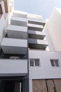 an external view of a white building with balconies at Opus Boutique Apartment in Alexandroupoli