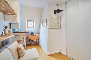 a living room with a couch and a kitchen at Charming Studio Arc de Triomphe Monceau in Paris