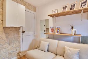 a living room with a couch and a stone wall at Charming Studio Arc de Triomphe Monceau in Paris