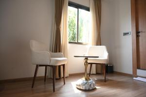 two chairs and a table in a room with a window at Brahmaputra Manor in Tezpur
