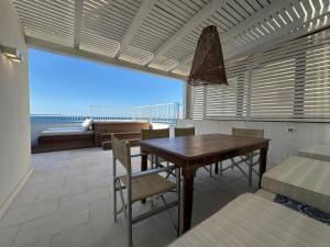 a dining room with a table and chairs and a bed at Cielomare Residence Diffuso in Trapani