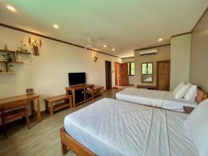 a hotel room with two beds and a television at Ancarine Beach Resort in Phú Quốc
