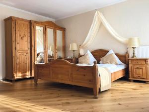 a bedroom with a wooden bed with a canopy at Gästehaus Maasberg in Bad Sobernheim