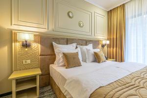 a bedroom with a large bed with white sheets and pillows at Davo Hotel in Târgu Neamț +75 photos