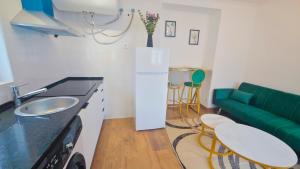 a kitchen with a sink and a green couch at Cascais Garden House 102 in Cascais