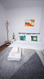 a bedroom with a large white bed with a rug at Cascais Garden House 102 in Cascais