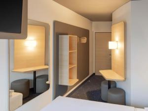 a room with a bed and a desk and shelves at B&B HOTEL Gießen-Linden in Gießen +18 photos