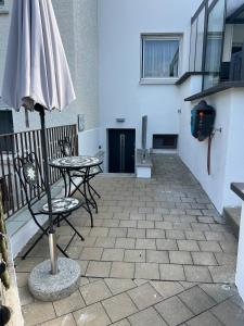 a patio with two tables and an umbrella at Moderne & gemütliche Pendleroase in Eislingen