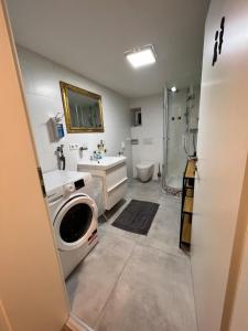 a bathroom with a sink and a washing machine at Moderne & gemütliche Pendleroase in Eislingen +9 photos