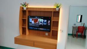 a flat screen tv in a wooden entertainment center at Tanah merah guest house in Singkawang
