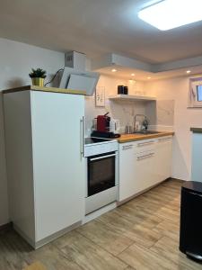 a kitchen with white cabinets and a white refrigerator at Moderne & gemütliche Pendleroase in Eislingen