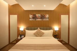 a bedroom with a large bed and two lamps at Brahmaputra Manor in Tezpur