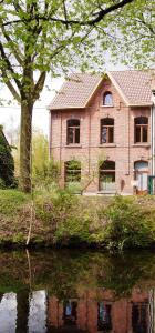 a house sitting next to a body of water at Klik Klak Studio in Bornem