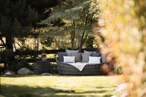 a couch sitting in the grass in a yard at DER MESNERWIRT - 4 Superior - Meraner Land in Avelengo