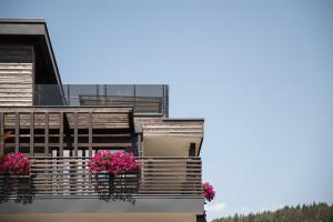 a building with two potted flowers on a balcony at DER MESNERWIRT - 4 Superior - Meraner Land in Avelengo