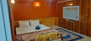 a small bedroom with a bed and a tv at indrapuri homestay in Darjeeling