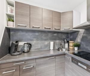 a kitchen with wooden cabinets and a sink at Prime Host perfect room in Karlsruhe