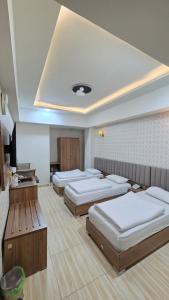 a room with four beds in a room at Al-Mahasen Hotel in An Najaf +88 photos