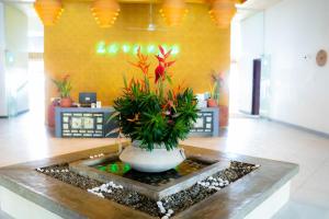 a lobby with a vase with plants in it at Lavanga Beach in Hikkaduwa