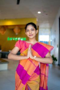 a woman in an orange and purple dress standing in a room at Lavanga Beach in Hikkaduwa