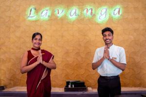 two men standing in front of a sign that reads karma at Lavanga Beach in Hikkaduwa