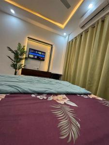 a bedroom with a bed and a tv in a room at istudio in Ghaziabad
